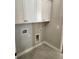 A neutral laundry room features tile floors and ample white cabinets at 3032 Farm Tract Trl, Woodstock, GA 30189