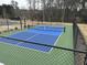 Enjoy this community pickleball court with a green and blue playing surface, surrounded by a black fence at 3032 Farm Tract Trl, Woodstock, GA 30189