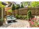 Serene backyard featuring a patio with lounge chairs, flower beds, and privacy fencing, creating a peaceful retreat at 3167 Blairhill Ct, Atlanta, GA 30340