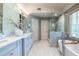 Elegant bathroom featuring a tub, glass shower, and double sink with light blue cabinetry at 3167 Blairhill Ct, Atlanta, GA 30340