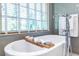Bright bathroom features a soaking tub, a window, and gray subway tile at 3167 Blairhill Ct, Atlanta, GA 30340