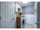 Well-lit laundry room with side-by-side washer and dryer, custom cabinetry, and tile flooring at 3167 Blairhill Ct, Atlanta, GA 30340