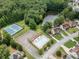 Aerial view showcasing community pool, tennis courts, lake, and surrounding homes in a lush, green neighborhood at 380 Chandler Ct, Sugar Hill, GA 30518