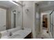 Neutral bathroom featuring a large mirror, modern sink, and bright vanity lighting at 380 Chandler Ct, Sugar Hill, GA 30518