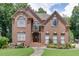 Charming two-story brick home boasts a beautiful front lawn and meticulously landscaped flower beds, enhancing its curb appeal at 380 Chandler Ct, Sugar Hill, GA 30518