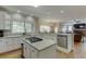 A kitchen island with granite countertops and an open layout connecting to the living area at 380 Chandler Ct, Sugar Hill, GA 30518