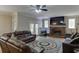 Open-concept living room with brick fireplace, ceiling fan, and hardwood floors at 380 Chandler Ct, Sugar Hill, GA 30518