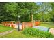 Backyard with outdoor kitchen featuring a wooden deck with a picnic table and spa at 426 College E St, Bowdon, GA 30108
