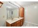 Bathroom featuring double sinks, wooden cabinets, and an ornate mirror with vanity lighting at 426 College E St, Bowdon, GA 30108