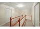 Upstairs hallway with carpet flooring, wood railings and trim and classic white doors at 426 College E St, Bowdon, GA 30108