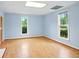 Bright living room featuring beautiful wood floors, two large windows and light blue walls at 426 College E St, Bowdon, GA 30108