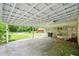 Covered outdoor patio with concrete floors, views of back yard and storage area at 426 College E St, Bowdon, GA 30108