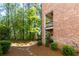 Sideyard view showcasing the brick facade, small yard, and balconies at 451 Burton Dr # 32, Alpharetta, GA 30009
