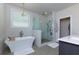 Modern bathroom featuring a standalone tub, a glass shower, and a window with natural light at 451 Burton Dr # 32, Alpharetta, GA 30009