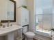 Half bath showcasing pedestal sink, white cabinetry, and natural light from a window at 451 Burton Dr # 32, Alpharetta, GA 30009