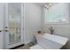 Bright bathroom with a soaking tub, brushed nickel faucet and a chandelier at 451 Burton Dr # 32, Alpharetta, GA 30009