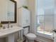 This half bath features a stylish pedestal sink, toilet, linen closet and window with natural light and modern fixtures at 451 Burton Dr # 32, Alpharetta, GA 30009