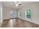 Bedroom featuring wood floors, a ceiling fan, natural light from windows, and glass door leading to balcony at 451 Burton Dr # 32, Alpharetta, GA 30009