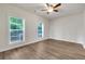 Bright bedroom with hardwood floors, ceiling fan, and natural light from two windows at 451 Burton Dr # 32, Alpharetta, GA 30009