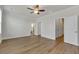 Spacious bedroom with hardwood floors, ceiling fan, natural light, and multiple entryways to closet and bathroom at 451 Burton Dr # 32, Alpharetta, GA 30009