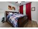 Comfortable bedroom boasts hardwood floors, a large sleigh bed and stylish red curtains at 451 Burton Dr # 32, Alpharetta, GA 30009