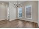 Dining room features wood floors, a modern chandelier and natural light through the double windows at 451 Burton Dr # 32, Alpharetta, GA 30009