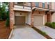 Exterior garage featuring brick exterior with garage doors and driveway with landscaping at 451 Burton Dr # 32, Alpharetta, GA 30009