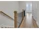Upstairs hallway showcasing wood floors, wooden railing with metal spindles, and access to other rooms in the home at 451 Burton Dr # 32, Alpharetta, GA 30009