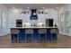 This kitchen features a large island with white countertop, blue base, and four stools, with modern appliances and plenty of cabinet space at 451 Burton Dr # 32, Alpharetta, GA 30009