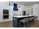 This kitchen features a large island with white countertop, blue base, and four stools, with modern appliances and plenty of cabinet space at 451 Burton Dr # 32, Alpharetta, GA 30009