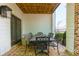 Charming covered patio with brick flooring, wrought iron table and chairs, and exterior building view at 451 Burton Dr # 32, Alpharetta, GA 30009