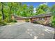 Beautiful single-story brick home boasts a spacious driveway and attached garage, surrounded by lush greenery and mature trees at 659 Pleasant Hill Nw Rd, Conyers, GA 30012
