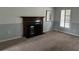 Cozy living room featuring a classic fireplace with dark wood mantel and neutral carpeting at 150 N Pond Ct, Roswell, GA 30076