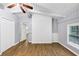 Spacious bedroom boasting wood-look floors, a ceiling fan, and a stylish white brick accent wall at 3458 Cooper St, Lithia Springs, GA 30122