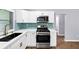 Stylish kitchen featuring stainless steel appliances, white cabinets, and a unique tiled backsplash at 3458 Cooper St, Lithia Springs, GA 30122