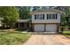 Split-level home featuring a two-car garage, brick facade, and lawn at 1349 Cedar Heights Dr, Stone Mountain, GA 30083
