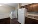 A view of the kitchen area with wood cabinets, hardwood flooring, and a white refrigerator at 1349 Cedar Heights Dr, Stone Mountain, GA 30083