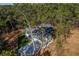 An aerial view shows the house with an attached garage surrounded by lush, mature trees at 16 Mountain Creek Ne Trl, Fairmount, GA 30139