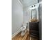 This half bathroom has a stylish round vessel sink, dark vanity, modern fixtures and wood flooring at 16 Mountain Creek Ne Trl, Fairmount, GA 30139