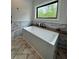 Modern bathroom featuring a soaking tub, tiled wall, and window with a scenic view at 16 Mountain Creek Ne Trl, Fairmount, GA 30139