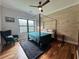 Modern bedroom features a four-poster bed, accent wall, ceiling fan, and window overlooking the trees at 16 Mountain Creek Ne Trl, Fairmount, GA 30139