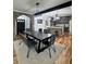 Dining room with kitchen view, showcasing wood beam, brick archway, and modern lighting at 16 Mountain Creek Ne Trl, Fairmount, GA 30139