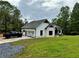 Home featuring white siding, black trim, a gray roof, an attached garage, and a spacious yard at 16 Mountain Creek Ne Trl, Fairmount, GA 30139