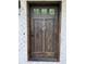 An inviting stained wood front door with decorative hardware on a charming brick home at 16 Mountain Creek Ne Trl, Fairmount, GA 30139