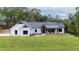 Charming white brick home with black accents, well-manicured lawn and covered porch at 16 Mountain Creek Ne Trl, Fairmount, GA 30139