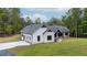 Side view of home showcasing a large garage with decorative black trim and beautiful landscaping at 16 Mountain Creek Ne Trl, Fairmount, GA 30139