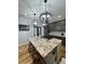 Granite island with cooktop, pendant lighting, and seating in a modern, well-lit kitchen at 16 Mountain Creek Ne Trl, Fairmount, GA 30139