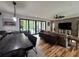 Open-concept living room with brick accent wall, sliding glass doors, and wood floors at 16 Mountain Creek Ne Trl, Fairmount, GA 30139