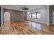Open-concept living room with hardwood floors, brick accents, and large windows offers great natural light at 16 Mountain Creek Ne Trl, Fairmount, GA 30139