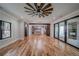 Open-concept living space with hardwood floors, fan, with kitchen view and sliding doors to stone fireplace at 16 Mountain Creek Ne Trl, Fairmount, GA 30139